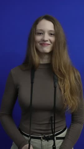 Young female photographer taking pictures in studio