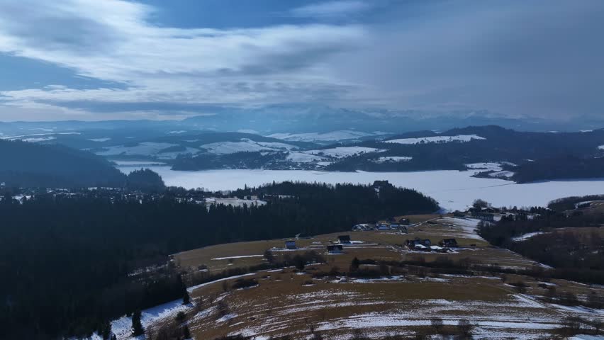 Aerial view of a winter landscape with snowy hills and serene lakes