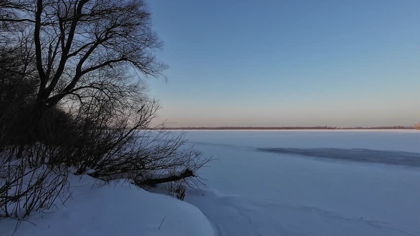 Frozen river in the forest in the evening, wide angle