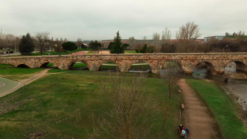 Aerial view of the ancient Roman stone bridge in Salamanca crossing the Tormes River. Historic landmark and architectural heritage in Castilla y León, Spain