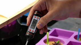 measuring temperature of melted wax while making homemade candles. - Powered by Shutterstock - Get 15% off with code: PIKWIZARD15