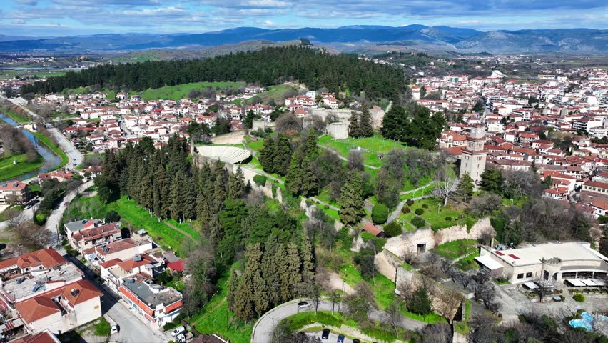 Aerial drone cinematic rotational video of iconic Byzantine castle of Trikala ancient citadel built northeastern side of the city in a small hill featuring clock tower with great views in old city of Trikala, Thessaly, Greece
