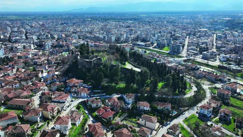 Aerial drone cinematic rotational video of iconic Byzantine castle of Trikala ancient citadel built northeastern side of the city in a small hill featuring clock tower with great views in old city of Trikala, Thessaly, Greece