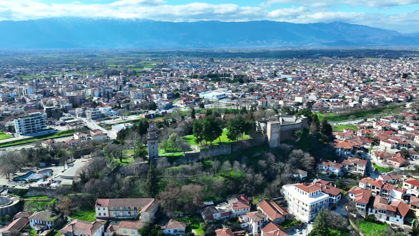 Aerial drone cinematic rotational video of iconic Byzantine castle of Trikala ancient citadel built northeastern side of the city in a small hill featuring clock tower with great views in old city of Trikala, Thessaly, Greece