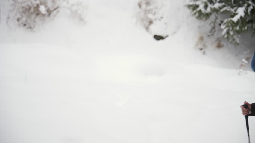 Group of friends with backpacks and trekking poles hiking through a snowy mountain trail. Adventure travelers enjoying the winter scenery during an outdoor activity in a beautiful alpine landscape