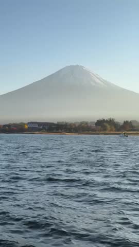 Scenic view of Mount Fuji under clear sky with surrounding landscape in Japan. Iconic Japanese volcano and popular travel destination with peaceful natural scenery.