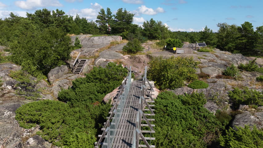 Aerial view backwards over a suspension bridge in Oro, summer day in Finland