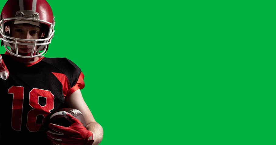 Male rugby player wearing a helmet holding a rugby ball pointing against black background. sports and fitness concept