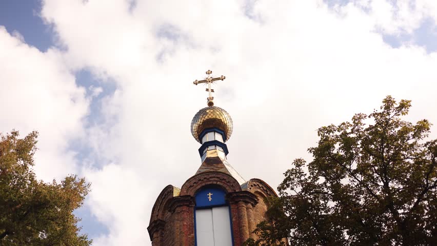 Orthodox church. Golden dome of the church with a cross. The sky floating clouds. St. Michael