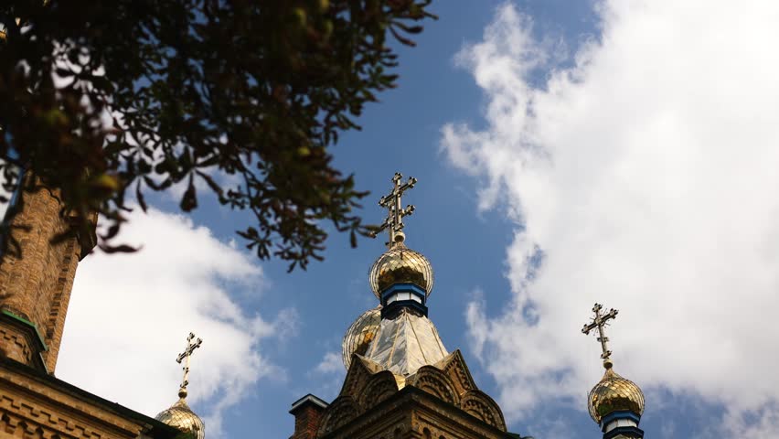 Orthodox church. Golden dome of the church with a cross. The sky floating clouds. St. Michael