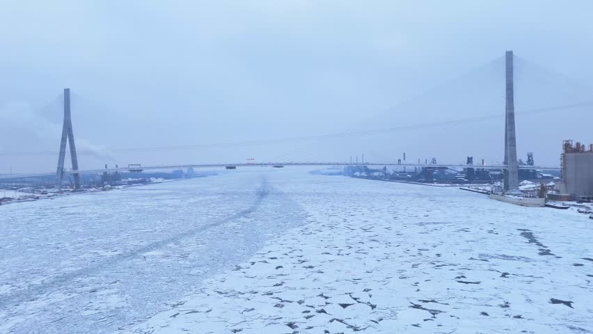 Gordie Howe International Bridge across the icy Detroit River during winter in aerial view