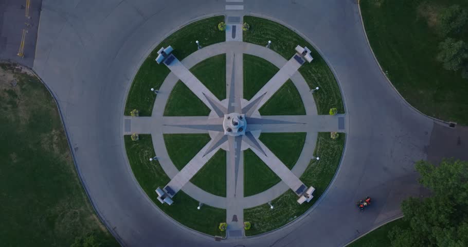 Aerial establishing of Martin Luther King Memorial in City Park Denver, drone top down ascend above compass rose monument