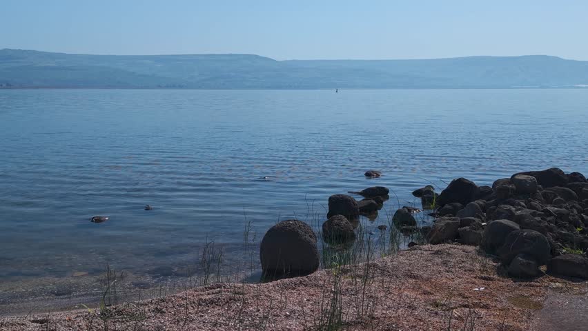 Sea of Galilee shore area with various water puddles during a lateral aerial slide right in Israel.