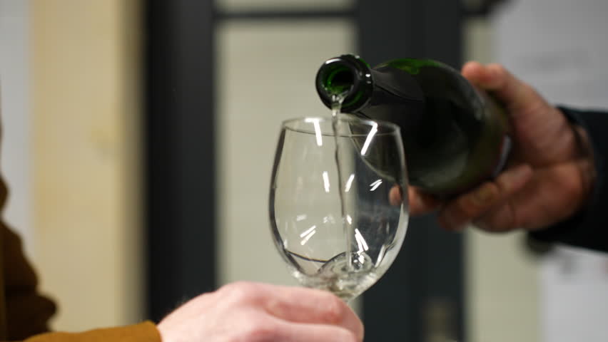 Pouring wine into glass for degustation, Belgium winery