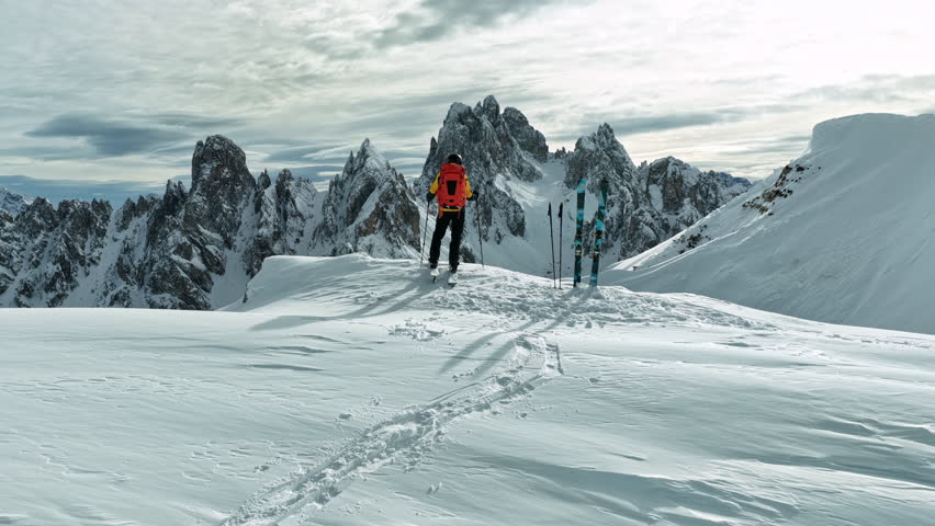Beautiful Winter Dolomite Mountain Scenery with Man on Cross-Country Skis , Aerial View