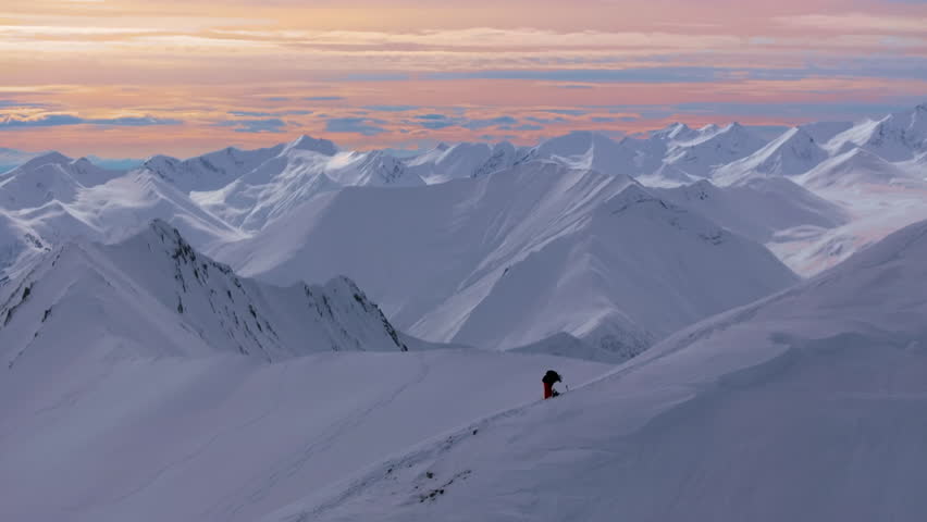 4K aerial drone footage capturing Gudauri Ski Resort in the Caucasus Mountains, featuring a snowboarder climbing up to the top of the mountain. Georgia_013