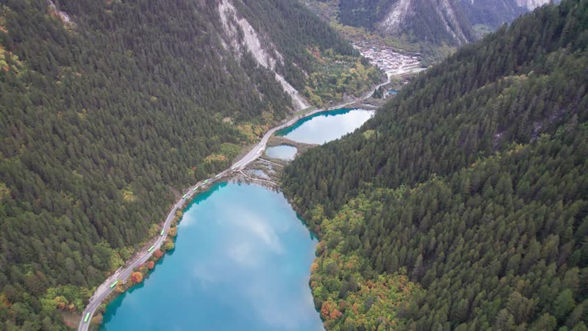 Drone view of Jiuzhaigou National Park in autumn in Sichuan Province China. It features cascading waterfalls, turquoise blue lakes, and stunning mountain valleys. 4K real time footage travel concept
