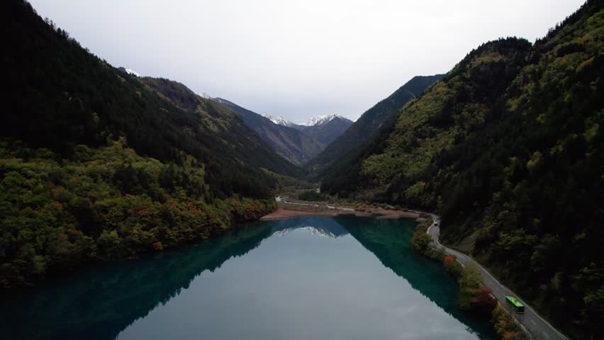 Drone view of Jiuzhaigou National Park in autumn in Sichuan Province China. It features cascading waterfalls, turquoise blue lakes, and stunning mountain valleys. 4K real time footage travel concept