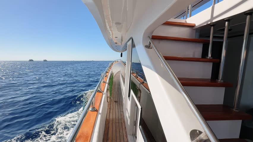 Close up yacht deck side view with stairs to the upper deck floating in the Sea 