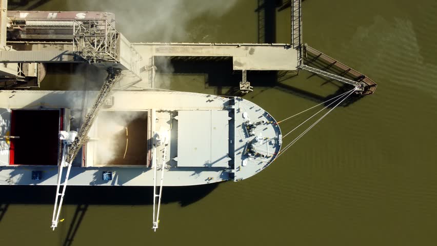 US, Oregon, Portland, 2026-02-15 - Drone view of grain being loaded from storage silos onto a bulk carrier ship on the Wilamette River at the Port of Portland Terminal 5, in Winter