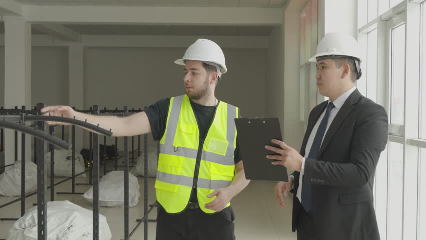 Engineer pointing at something to colleague on construction site