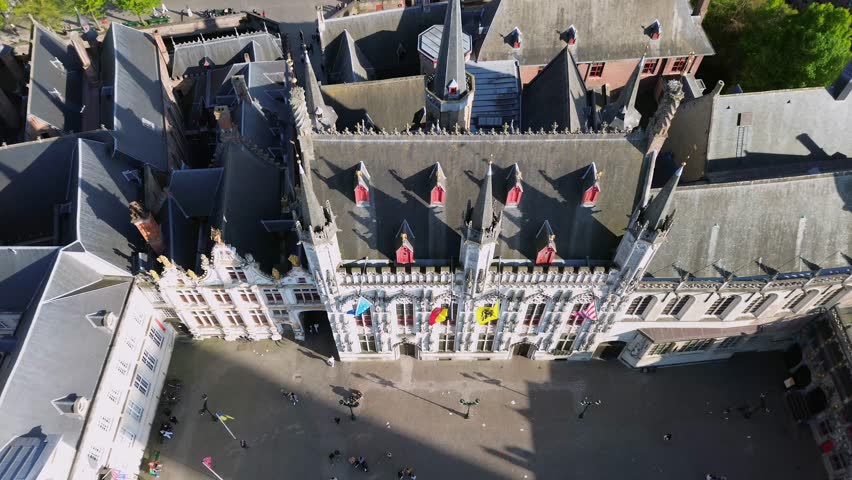Cinematic drone shot of the historic Burg Square and the Gothic City Hall in Bruges Belgium featuring medieval architecture of this UNESCO World Heritage site for travel and history films