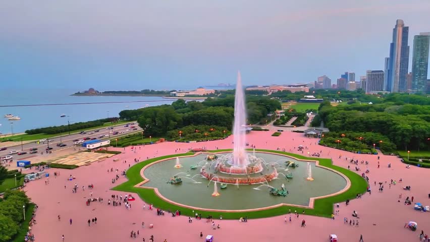 Circling shot of Birmingham Fountain in Millenium Park In Chicago with the Chicago Skyline at sunset