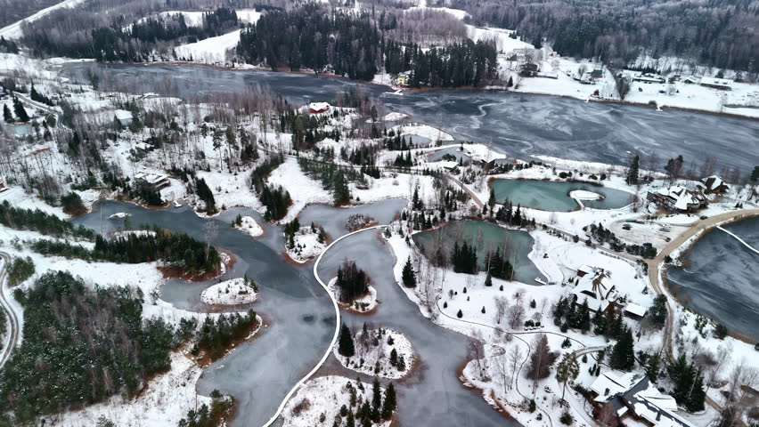Overhead view of a frozen water landscape with lakes, forests and meadows criss-crossing each other.