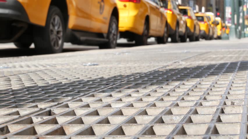 Manhattan Midtown street New York City, United States. Defocused row of yellow taxi cars. Many taxi cabs in line on 8th avenue near Penn Station. Taxi queue, urban road traffic, passenger transport.