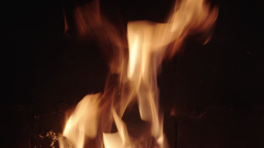 Flames dancing in rhythmic motion under night sky fire pit glow