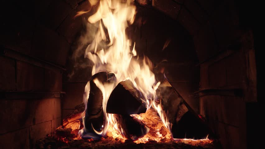 Firewood burning in a cozy fireplace during a winter evening