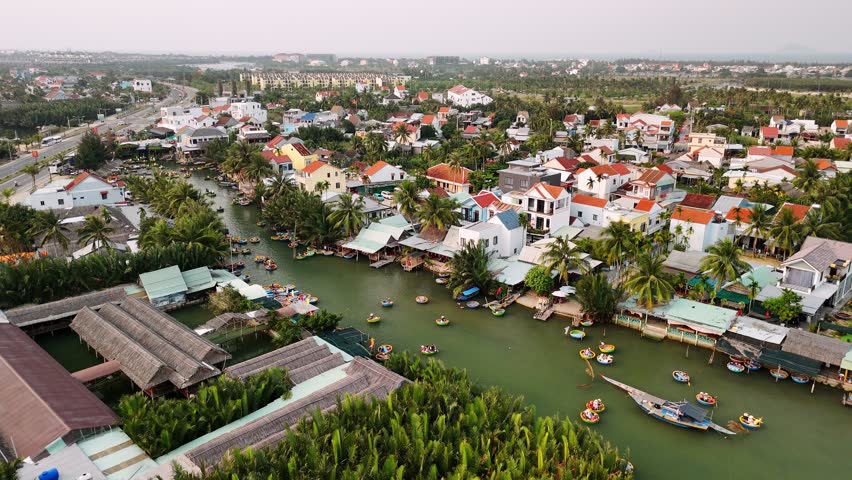 Aerial view of tourists riding traditional coconut boats on thu bon river in hoi an, vietnam ancient town.