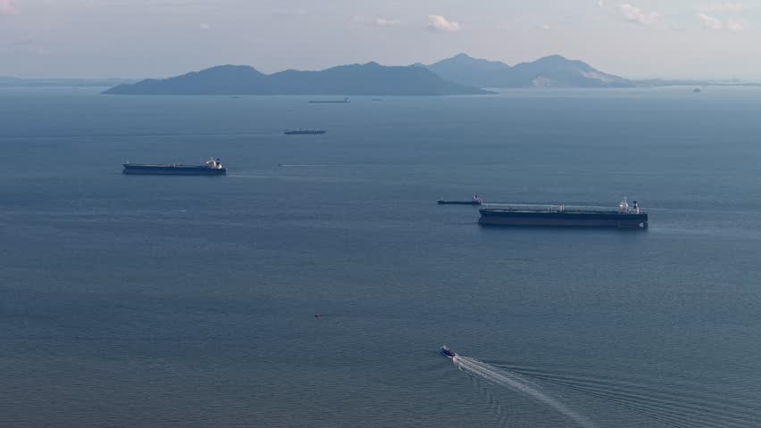 A breathtaking aerial view of ships sailing on tranquil ocean waters at Straits of Malacca