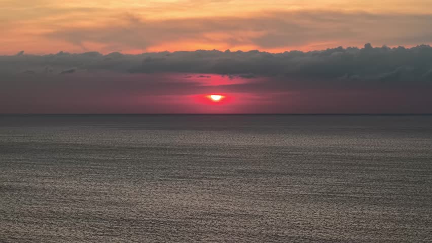 Sunset over Sungai Burung and Balik Pulau shoreline, ocean horizon and cloud layers.