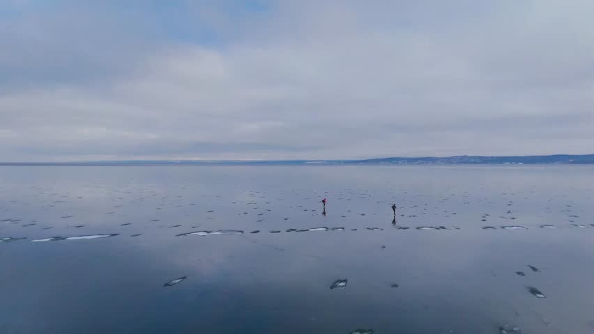 Aerial View of Two Paddleboarders on Frozen Lake.