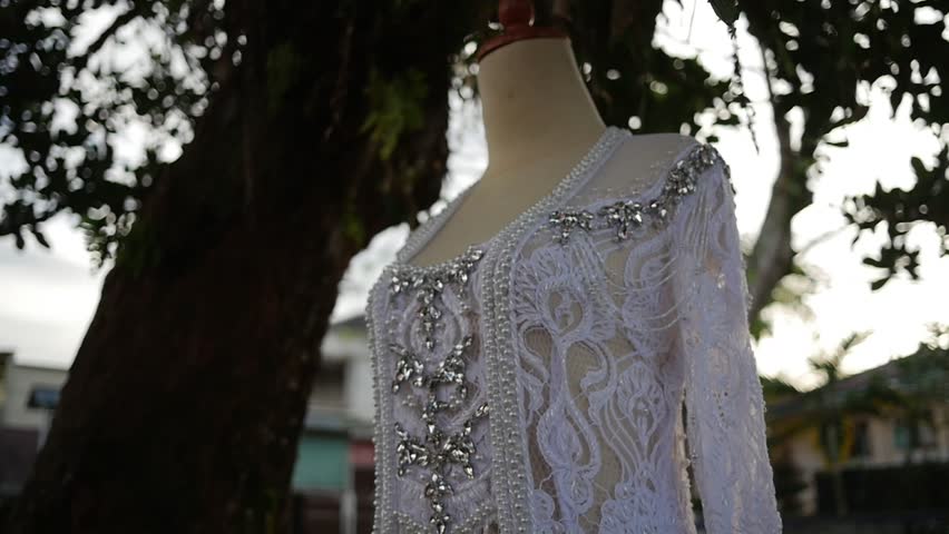 Traditional Southeast Asian white wedding dresses complete with decorations and ornaments, and are worn by the bride and groom. Real time outdoor natural lighting RAW no edit footage video file