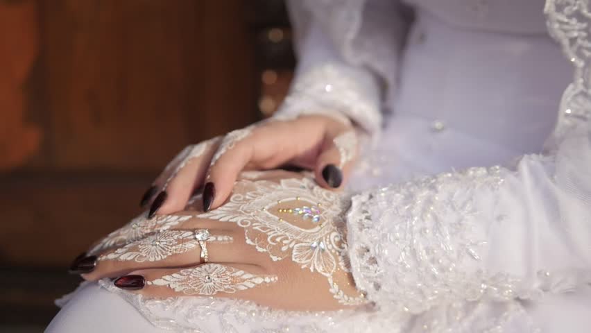 Traditional Southeast Asian white wedding dresses complete with decorations and ornaments, and are worn by the bride and groom. Hand closeup. Real time outdoor natural lighting RAW no edit footage video file