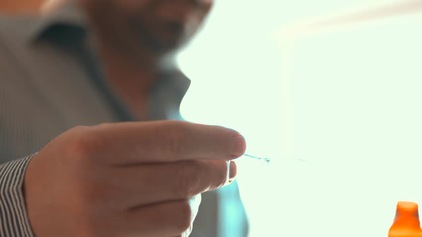 Man pouring liquid cough syrup into a spoon, medication dosage and healthcare concept.