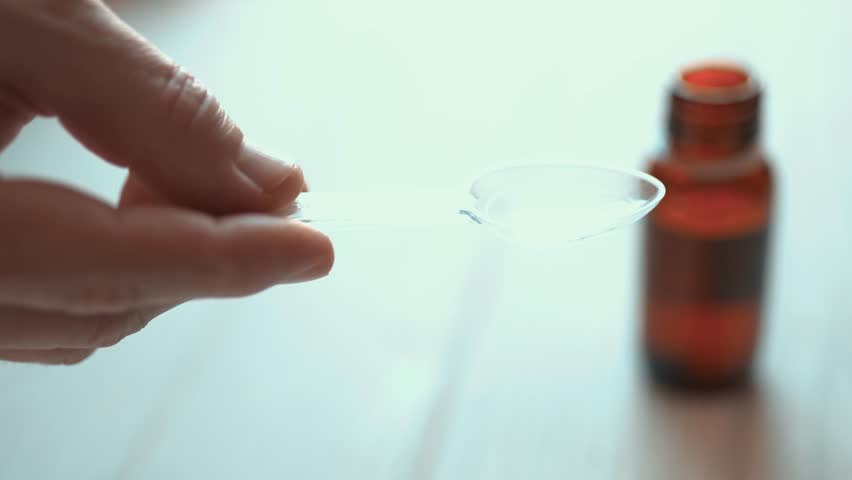 Man pouring liquid cough syrup into a spoon, medication dosage and healthcare concept.