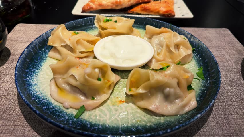 Manti with sour cream, is a traditional Central Asian dish. Manti is steamed from minced meat lamb or or beef and onions in a thin unleavened dough.
