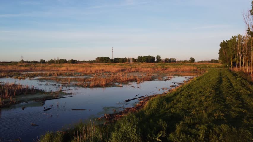 Aerial shots of Nature Preserve off the coast of Lake Michigan in Green Bay Wisconsin at sunrise. Rising drone shot over marsh land.