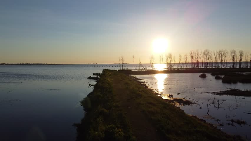 Aerial shots of Nature Preserve off the coast of Lake Michigan in Green Bay Wisconsin at sunrise. Low drone approach shot of grass path.