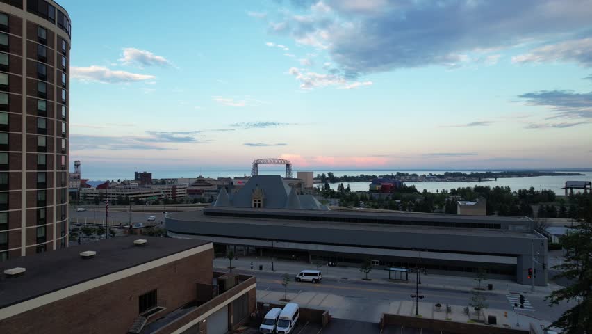 Aerial of downtown Duluth Minnesota at dusk.  Rising Approach shot towards Lake Superior over highway with Bridge in the distance.