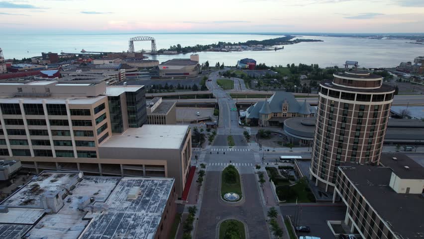 Aerial of downtown Duluth Minnesota at dusk.  Approach shot towards Lake Superior over highway with Bridge in the distance.