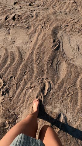 Woman walking on the sand and entering the sea with turquoise water in Greece in Vertical video