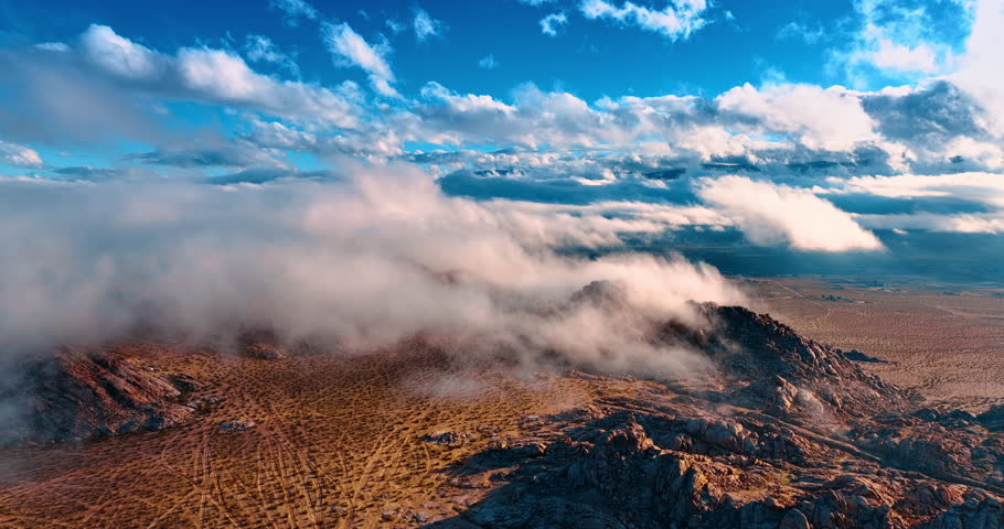 Fantastic azure sky with lovely fluffy clouds floating by. Footage over the beautiful arid landscape of Joshua Tree National Park, California, USA.