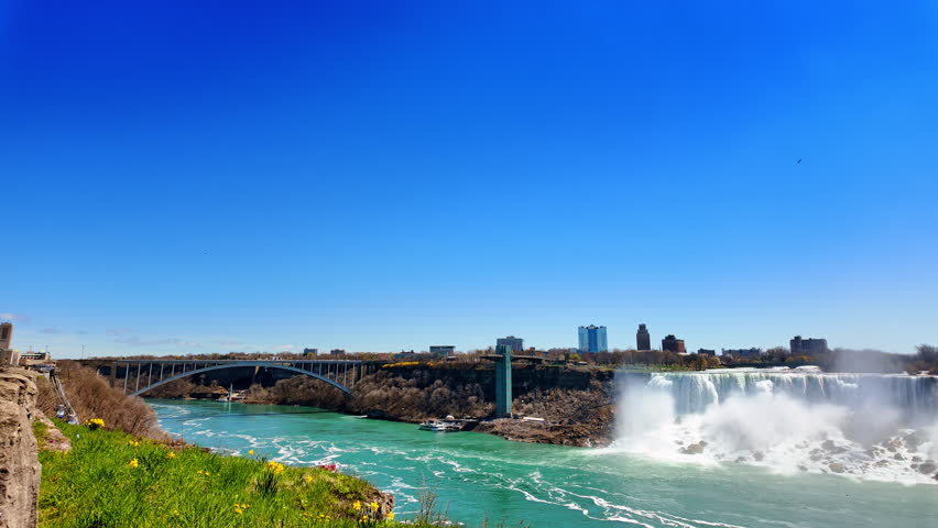 Magnificent Niagara Falls on the border between Canadian province of Ontario and the USA state of New York. View on the Rainbow bridge from the Canadian side.