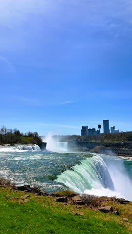 Wonderful Niagara Falls from the American side. Buildings in the skyline of Ontario province at the Canadian side at backdrop. Vertical video.