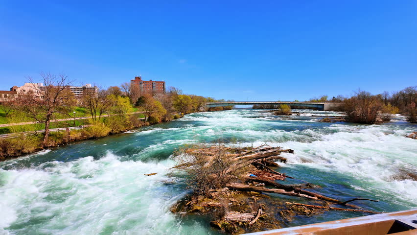 Rapids of the American Falls at Niagara Falls State Park in New York, US. Looking towards the Canadian side. Clear blue sky at backdrop.