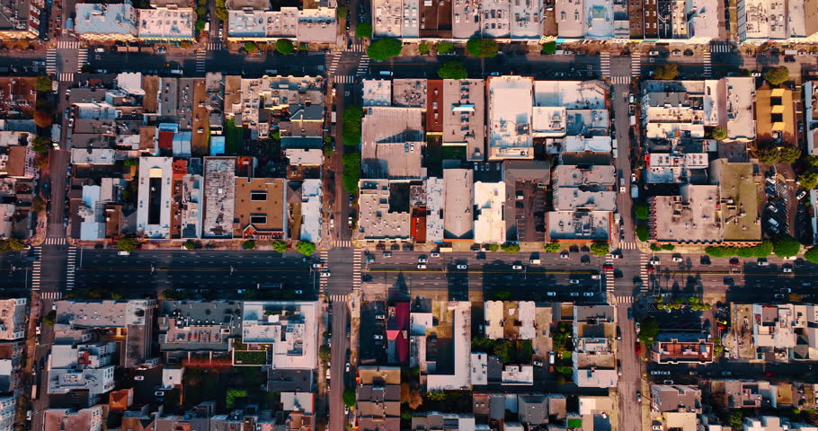 Cars move by the roads among the blocks of the modern city. Drone footage over the urban cityscape of San Francisco, California, USA.